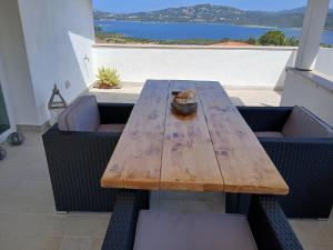 a wooden table and chairs with a view of the ocean at Villa Ginepro in Olbia