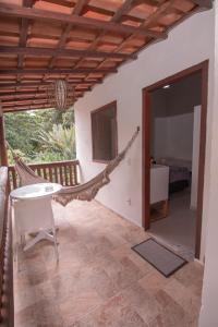 a room with a hammock and a bedroom at Pousada do Mineiro in Trancoso