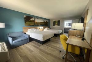 a hotel room with two beds and a desk and a chair at Days Inn & Suites by Wyndham York in York +44 photos