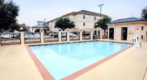 a large swimming pool in front of a building at Quality Inn & Suites Airport in Austin