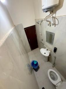 a small bathroom with a toilet and a sink at KRISHNAM GUEST HOUSE in Gwalior +1 photo