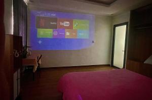 a bedroom with a large projection screen on the wall at Trần Lê Hostel in Da Lat