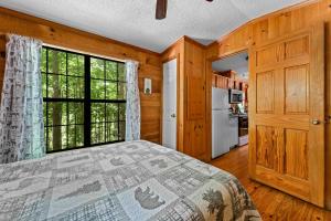 a bedroom with a bed and a large window at Cozy Cabin, Fireplace, WiFi, Hot Tub, Views! in Sevierville