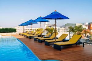 a row of yellow lounge chairs and umbrellas next to a pool at Days Inn by Wyndham Patong Beach in Patong Beach