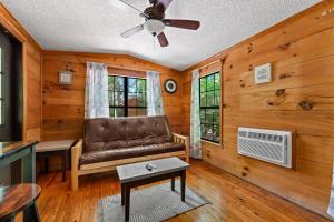 a living room with a couch and a ceiling fan at Cozy Cabin, Fireplace, WiFi, Hot Tub, Views! in Sevierville
