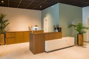 a waiting area with plants in a lobby at Aspire Palais Recklinghausen, Trademark Collection by Wyndham in Recklinghausen