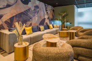 a living room with a couch and tables and chairs at Aspire Palais Recklinghausen, Trademark Collection by Wyndham in Recklinghausen