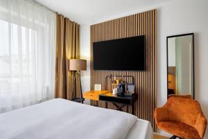 a hotel room with a bed and a desk and a television at Aspire Palais Recklinghausen, Trademark Collection by Wyndham in Recklinghausen +61 photos