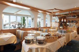 a restaurant with tables with food on them at Hotel Alpenhof in Tirolo