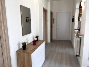 a hallway with a mirror and a counter with plants at Appartamento ALöa in Loano +23 photos
