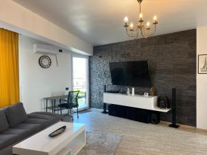a living room with a couch and a tv on a brick wall at EFORIE STUDIOS in Eforie Nord