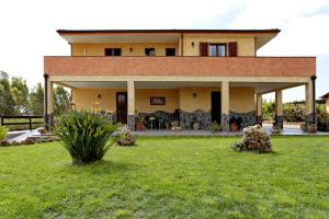 una casa con un cortile verde davanti di Bed and breakfast Le Camelie ad Alghero