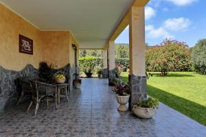 a patio with a table and chairs and plants at Bed and breakfast Le Camelie in Alghero