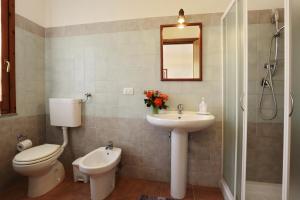 un bagno con un water, un lavandino e uno specchio di Bed and breakfast Le Camelie ad Alghero