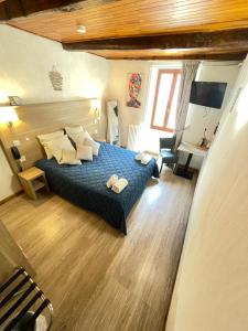 Postel nebo postele na pokoji v ubytování Hôtel Du Cheval Blanc Barcelonnette