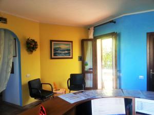 an office with a desk and two chairs and a window at Residence Costa Del Turchese in Badesi