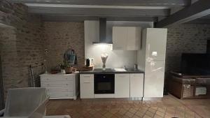 a kitchen with white cabinets and a white refrigerator at Charming house in Auvernaux