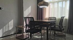 une table de salle à manger avec des chaises noires et une lampe dans l'établissement GreenTree Inn Anqing Tongcheng South Shengtang Road Shengtang International Business Hotel, à Wangguolu 137 autres photos