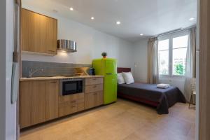 a kitchen with a green refrigerator next to a bed at Palais Saint Pierre in Cagnes-sur-Mer