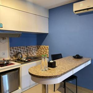 a kitchen with a counter and a blue wall at Kyriad Haka Makassar in Makassar