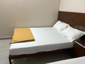 a bed with a yellow blanket on top of it at Vasavi Palace Residency in Pennāttūr +11 photos