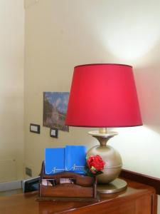 スカウリにあるHotel Auroraの本を持つテーブルに座る赤灯