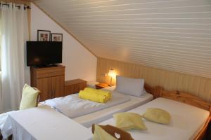 a bedroom with two beds and a television in it at Hotel Pension Schwaiger in Sankt Margarethen im Lungau