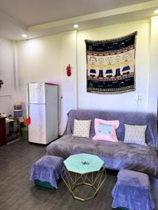 a living room with a purple couch and a refrigerator at Homestay Lac Long Quan by the Sea in Bình Sum