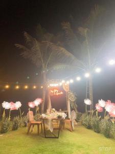 a party with a table and chairs and palm trees at Homestay Lac Long Quan by the Sea in Bình Sum