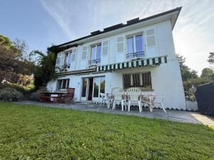 a white house with tables and chairs in front of it at Villa Laura in Lausanne