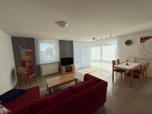 a living room with a red couch and a table at Ferienwohnungen Günther Hund in Immenstaad am Bodensee