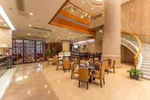 a restaurant with tables and chairs in a building at Swiss-Belhotel Blulane in Manila