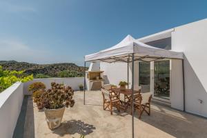 a patio with a table and an umbrella at Kondylis Cottage in Provatas