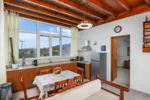 a kitchen with a table and a large window at Kondylis Cottage in Provatas