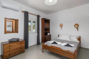 a bedroom with a bed and a dresser and a mirror at Kondylis Cottage in Provatas