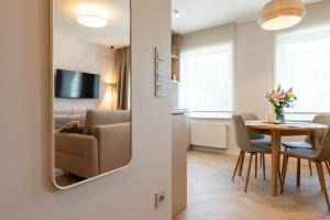 a living room with a dining room table and a mirror at Apartament Wejhera II in Puck