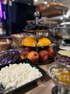 a table topped with plates of fruit and other foods at VATRA HOTEL in Ternopil +29 photos