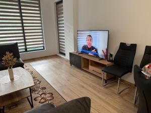 a living room with a flat screen tv on a table at Nikol5 Deluxe in Velingrad