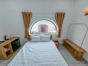 a bedroom with a bed and a window at D&T House in Cù Lao Thu