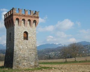 wysoka ceglana wieża w środku pola w obiekcie Affittacamere Dormire Caldi w mieście Trichiana