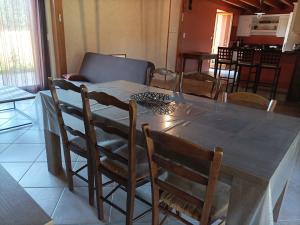 a dining room table with chairs and a table and a couch at Maison de campagne en Auvergne in Champagnac-le-Vieux