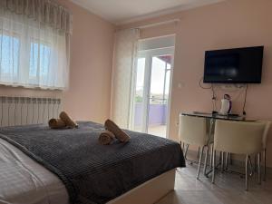 a bedroom with a bed and a table and a television at ApartHotel Viola in Pula +91 photos