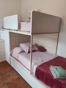 a bedroom with a bunk bed with pink sheets at Casa Santa Creu - Private family villa in nature in Piera