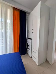 a bedroom with a bed and a washing machine at Liza's apartments in Shëngjin