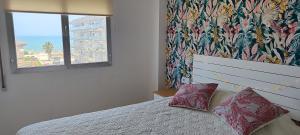a bedroom with a bed with two pillows and a window at Ocean front apartment Trianon in Daimuz