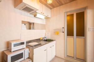 a small kitchen with a sink and a microwave at Lazurite GUESTHOUSE Pear Field in Inagi +17 photos