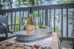 a bottle of wine sitting on a table with glasses at Snug Lake View Condo The Shores in Traverse City