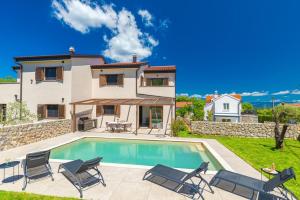 a villa with a swimming pool in front of a house at Casa del Sole in Lakmartin