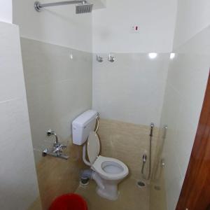 a small bathroom with a toilet and a shower at Premier Guest House in Kolkata