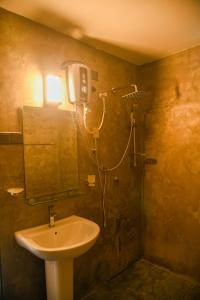 a bathroom with a sink and a shower at The Wild Side Cottage in Udawalawe